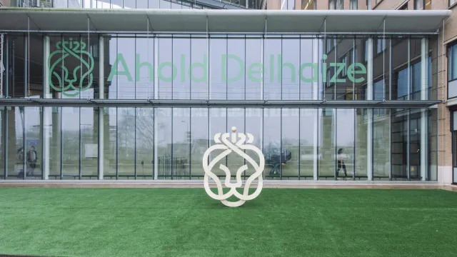 อาคารสำนักงานใหญ่ของ Ahold Delhaize พร้อมโลโก้บริษัทบนกระจกและประติมากรรมโลโก้หน้าอาคาร