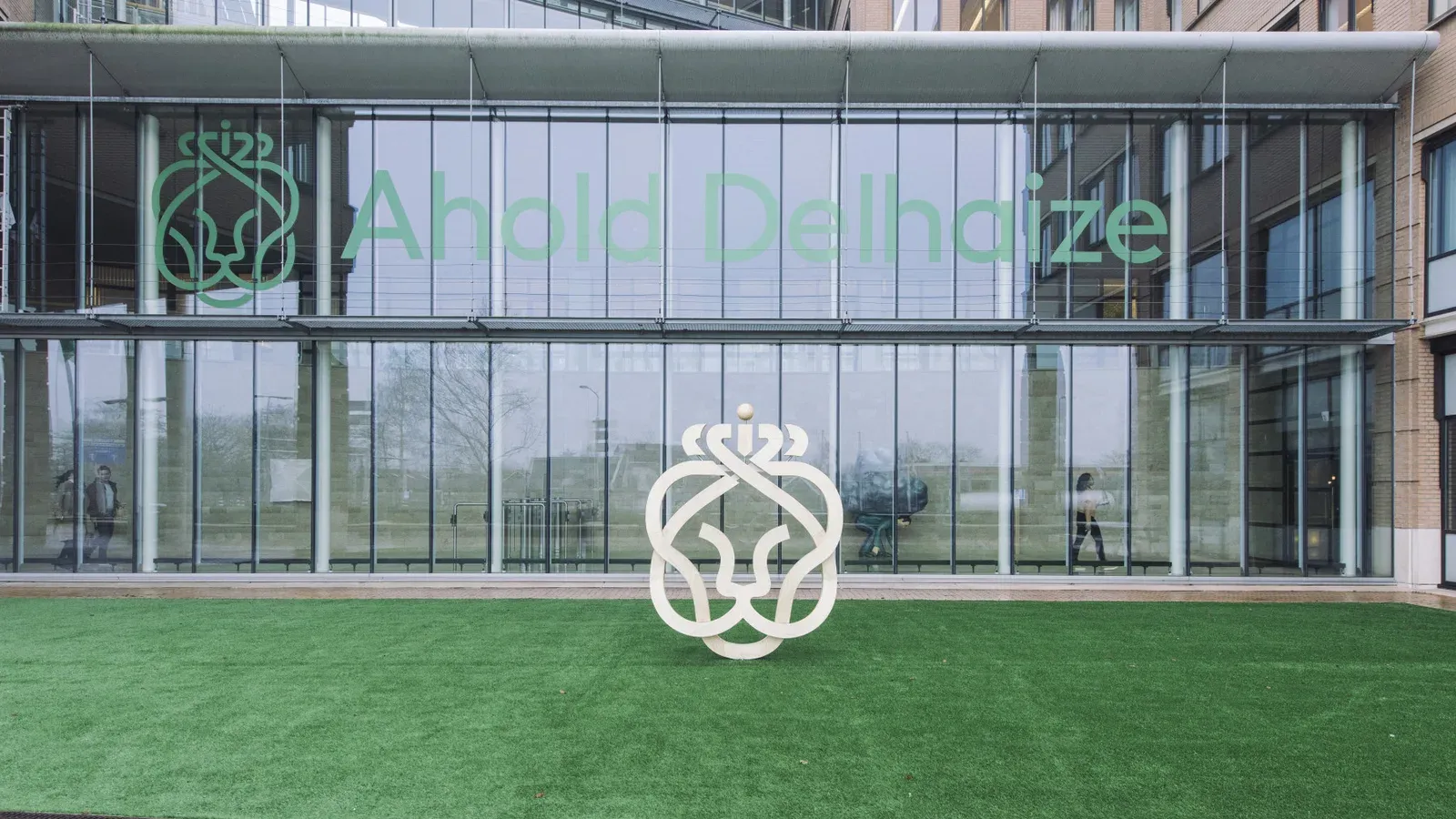 อาคารสำนักงานใหญ่ของ Ahold Delhaize พร้อมโลโก้บริษัทบนกระจกและประติมากรรมโลโก้หน้าอาคาร