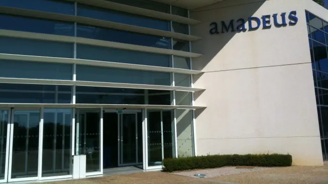 ทางเข้าสำนักงาน Amadeus ในเมืองนีซ ประเทศฝรั่งเศส อาคารกระจกมีชื่อบริษัทบนผนัง