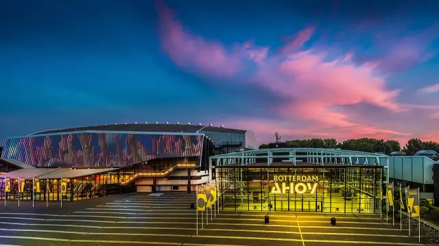 อาคาร Rotterdam Ahoy เมืองรอตเตอร์ดัม สนามแข่งยิมนาสติกชิงแชมป์โลก 2026 ยามพลบค่ำ ป้ายไฟ ROTTERDAM AHOY ที่ทางเข้ากระจก ถ่ายปี 2016