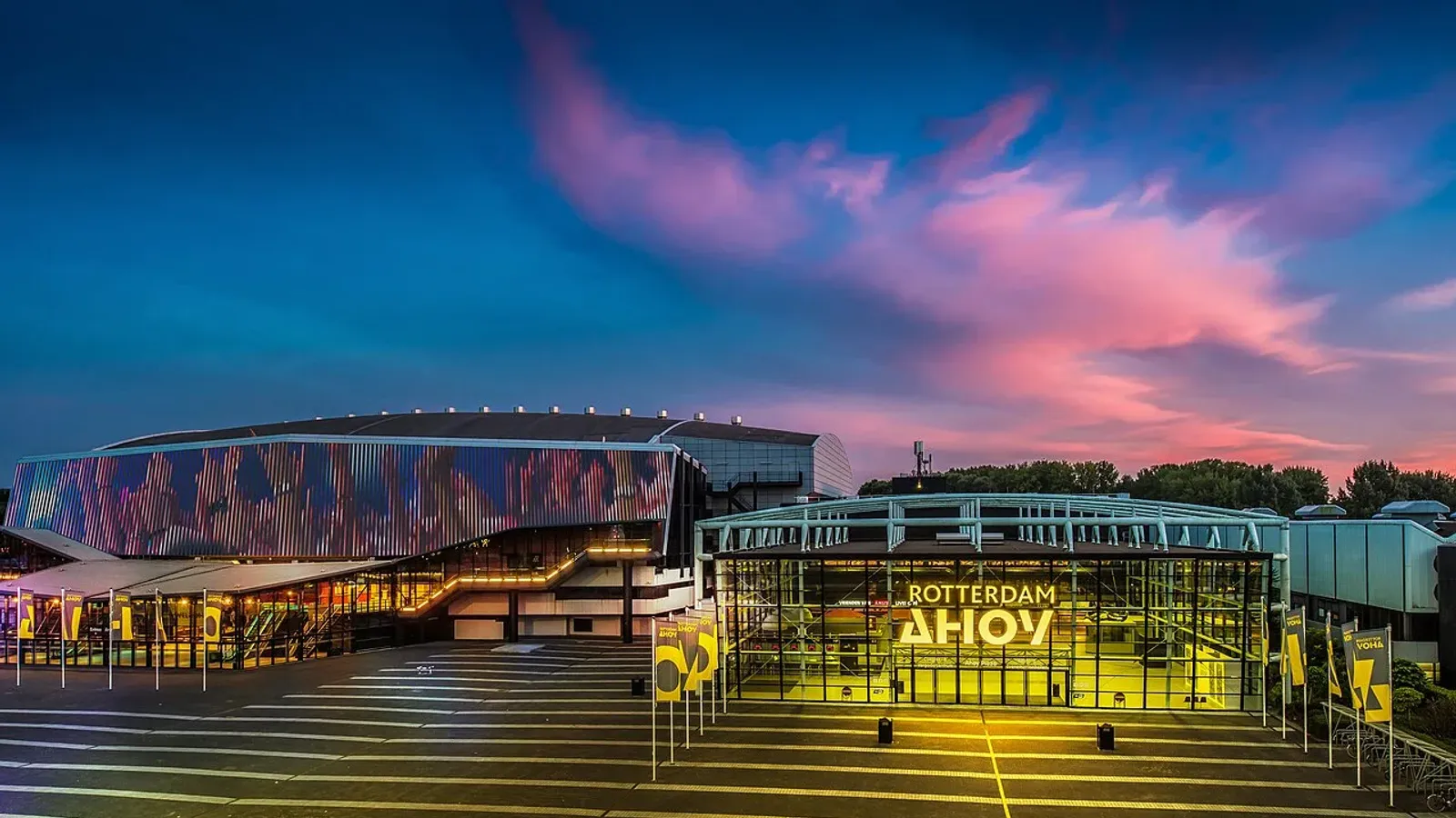 อาคาร Rotterdam Ahoy เมืองรอตเตอร์ดัม สนามแข่งยิมนาสติกชิงแชมป์โลก 2026 ยามพลบค่ำ ป้ายไฟ ROTTERDAM AHOY ที่ทางเข้ากระจก ถ่ายปี 2016