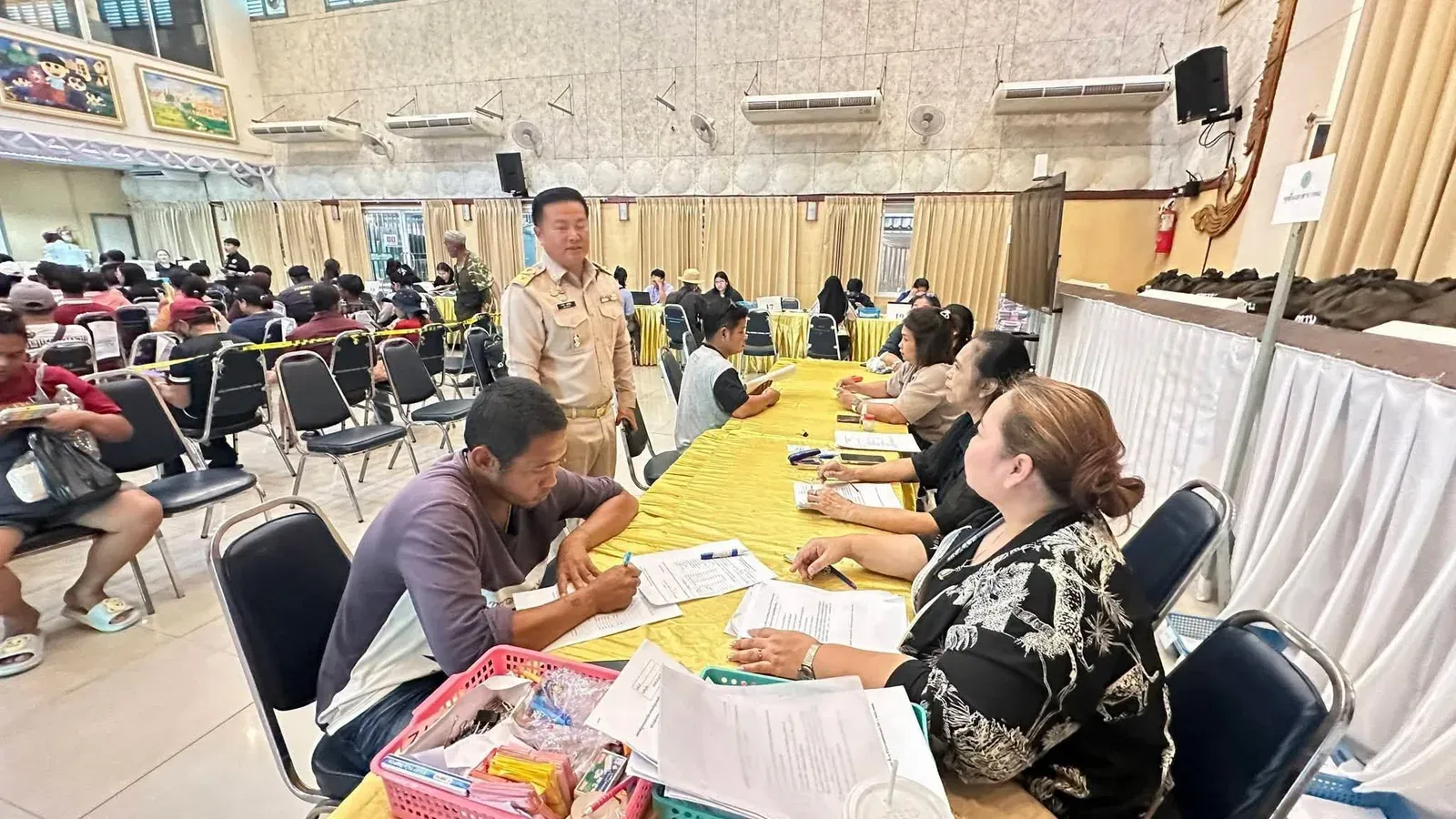 ประชาชนกรอกเอกสารขอเงินช่วยเหลือน้ำท่วม กทม. ที่จุดบริการของสำนักงานเขตในกรุงเทพมหานคร