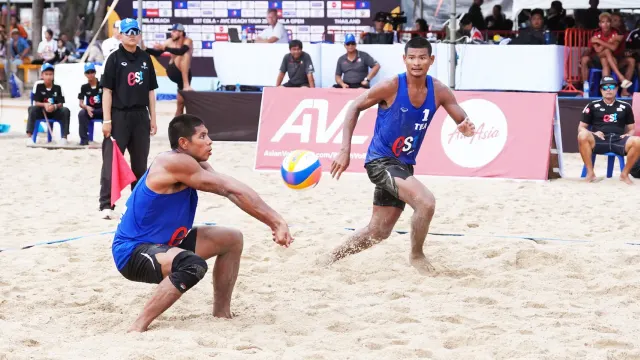 นักวอลเลย์บอลชายหาดชายทีมชาติไทยสองคนในเสื้อแข่งสีน้ำเงิน THA ย่อตัวรับลูกบนสนามทราย AVC Beach Tour Samila Open 2026 ที่สงขลา ภาพประกอบข่าววอลเลย์บอลชายหาด U21 ร้อยเอ็ด