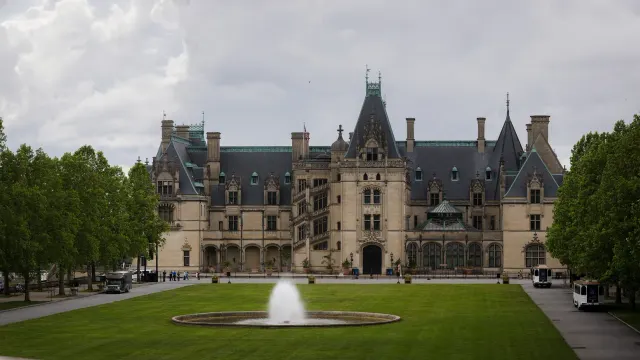 ด้านหน้า Biltmore House ใน Biltmore Estate มองจากลาน Esplanade เห็นสนามหญ้า น้ำพุ และแนวต้นไม้สองข้าง