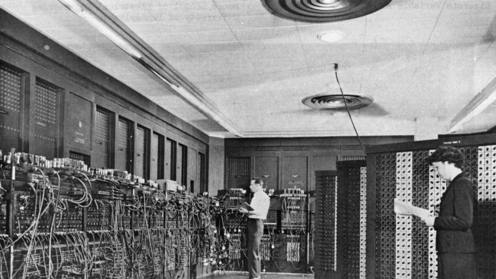 คอมพิวเตอร์ ENIAC ในอาคาร 328 ของห้องปฏิบัติการวิจัยขีปนวิธีที่ Aberdeen Proving Ground รัฐแมริแลนด์ Glen Beck (ด้านหลัง) และ Betty Snyder (ด้านหน้า) กำลังตั้งโปรแกรมเครื่อง ภาพถ่ายของกองทัพบกสหรัฐฯ