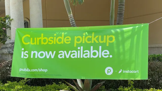 ป้าย Curbside pickup ของ Publix ร่วมกับ Instacart หน้าซูเปอร์มาร์เก็ตในเมืองไมอามี ปี 2020 บริการของแพลตฟอร์มในดีล DoorDash ซื้อ Instacart