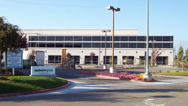 อาคารสำนักงานใหญ่ของ Webvan Group เลขที่ 310 Lakeside Drive เมือง Foster City รัฐแคลิฟอร์เนีย มีป้ายชื่อบริษัทอยู่หน้าอาคาร ภาพถ่ายภายหลังเมื่อ 17 กันยายน 2001 หลังบริษัทยื่นล้มละลาย