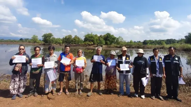 เกษตรกรและเจ้าหน้าที่เกษตรถือเอกสารริมแปลงที่ถูกน้ำท่วมในจังหวัดปราจีนบุรี ขั้นตอนยื่น กษ 01 น้ำท่วม 2569