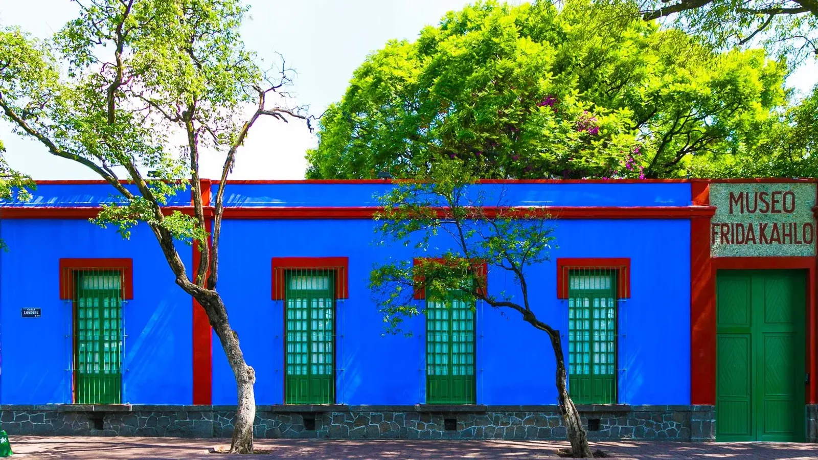 บ้านฟรีด้า คาห์โล หรือ Casa Azul ผนังสีน้ำเงินขอบแดง หน้าต่างสีเขียว และป้าย Museo Frida Kahlo ภาพถ่ายเดือนพฤศจิกายน 2022