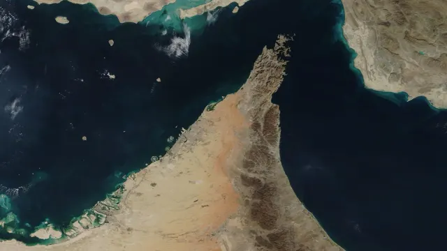 ภาพถ่ายดาวเทียม MODIS ของ NASA วันที่ 4 ธันวาคม 2020 แสดงช่องแคบฮอร์มุซระหว่างอิหร่านทางเหนือกับคาบสมุทรอาหรับทางใต้ เชื่อมอ่าวเปอร์เซียกับอ่าวโอมาน พื้นที่ที่มีการโจมตีห้องเครื่องเรือถี่ขึ้นในเดือนตุลาคม 2026