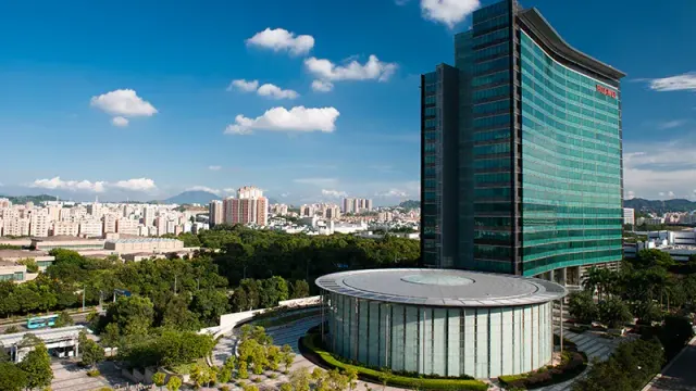 อาคารสูงกระจกสีเขียวที่มีป้าย HUAWEI และอาคารทรงกลมด้านหน้า ภาพที่ Huawei ใช้ประกอบประกาศข้อตกลงสิทธิบัตรกับ Qualcomm เมื่อ 5 ตุลาคม 2026
