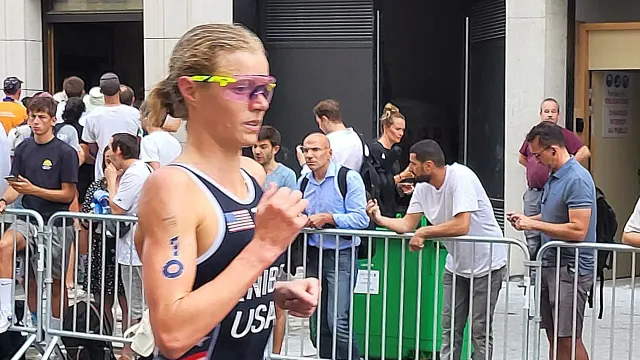 Taylor Knibb นักไตรกีฬาสหรัฐอเมริกาในชุดไตรสูททีมชาติ หมายเลข 10 แว่นกันแดด และรองเท้าวิ่ง ระหว่างช่วงวิ่งไตรกีฬาหญิงโอลิมปิกเกมส์ปารีส 2024 ก่อนคว้าแชมป์ไอรอนแมน ชิงแชมป์โลก 2026