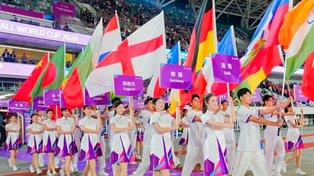 ขบวนพาเหรดถือธงชาติและป้ายชื่อทีมในพิธีเปิดฟุตบอลนักเรียนชิงแชมป์โลก 2026 ที่ Suzhou Sports Centre Stadium
