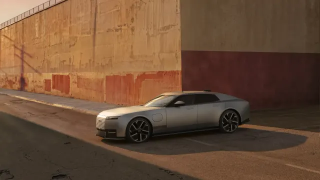 Jaguar Type 01 สีเงิน มุมด้านหน้าเฉียง จอดริมถนนข้างกำแพงคอนกรีต