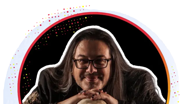 John Romero Lifetime Achievement Award 2026 ผู้ได้รับรางวัลวางมือบนหัวกะโหลกจำลอง ภาพจากหน้าวิทยากรของ gamescom asia x Thailand Game Show