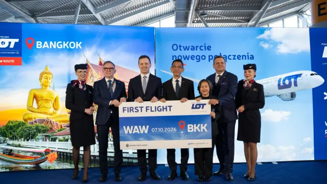 ผู้บริหาร LOT Polish Airlines และแขกร่วมงานถือป้าย First Flight WAW 07.10.2026 BKK ที่ท่าอากาศยานโชแปง วอร์ซอ