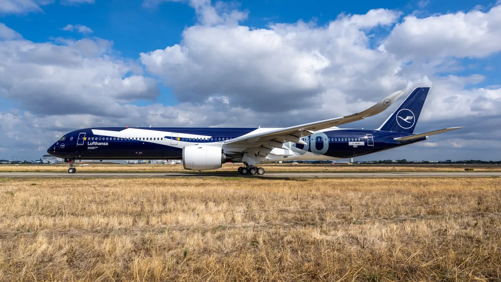 เครื่องบิน Airbus A350-1000 ของ Lufthansa ลายฉลองครบรอบ 100 ปี บนทางวิ่ง เครื่องบินรุ่นใหม่ที่ Lufthansa จะเริ่มใช้บินระยะไกลปลายปี 2026