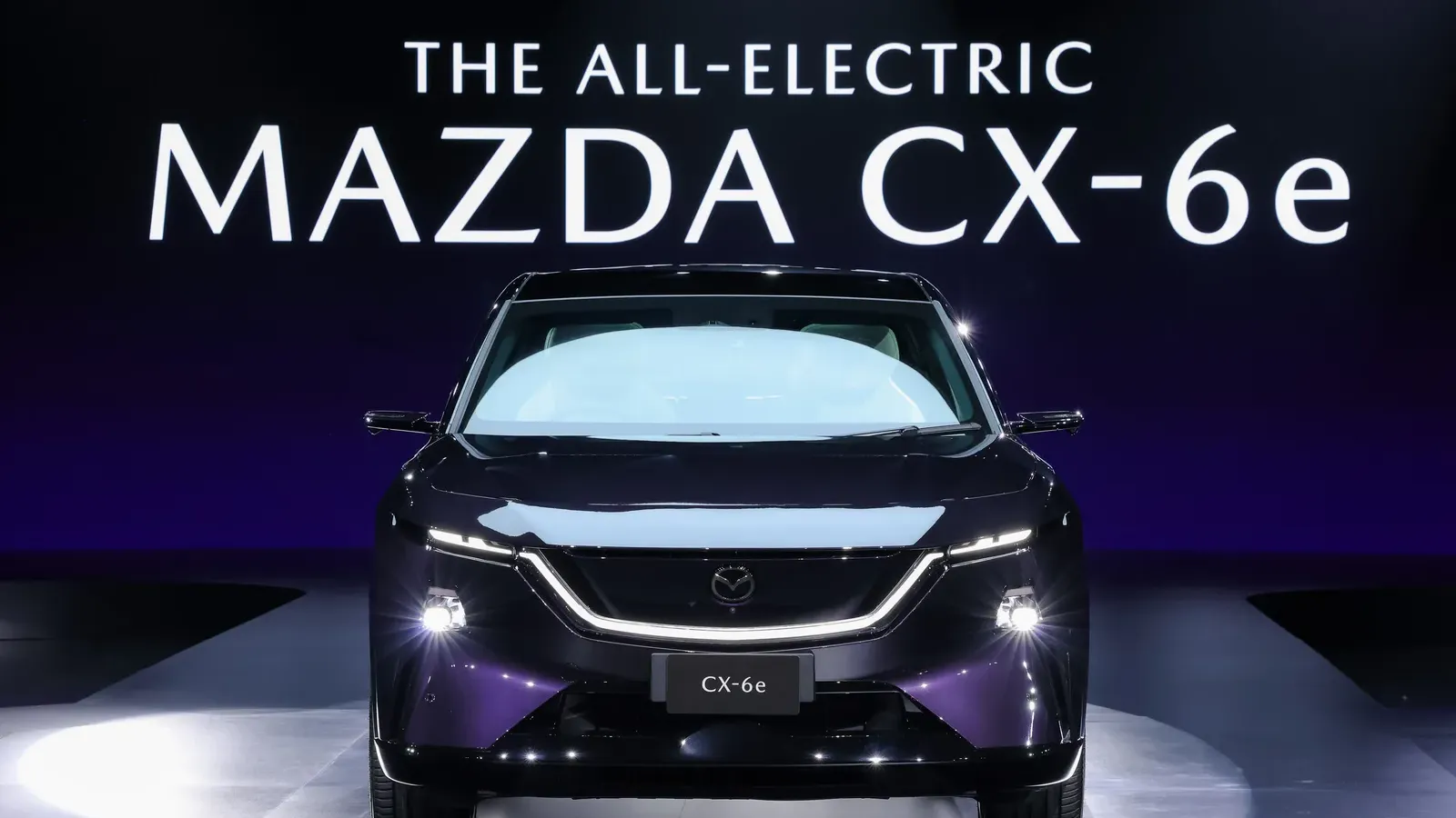 Mazda CX-6e มุมด้านหน้าบนเวทีงานเปิดตัวในไทย มีชื่อ THE ALL-ELECTRIC MAZDA CX-6e บนจอด้านหลัง