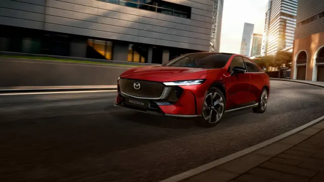 Mazda6e สีแดงแล่นบนถนนระหว่างอาคารสูง ภาพจากหน้ารุ่นรถของ Mazda ประเทศไทย