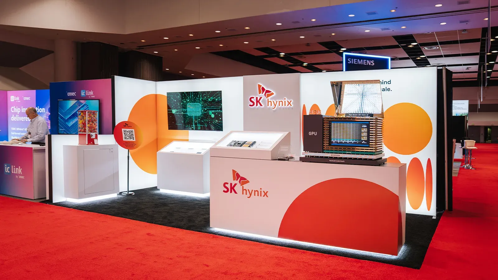 บูธของ SK hynix ในงาน TSMC OIP ปี 2026 ที่ซานตาคลารา มีโมเดลจำลองแพ็กเกจ GPU กับหน่วยความจำ HBM วางบน interposer และ package substrate
