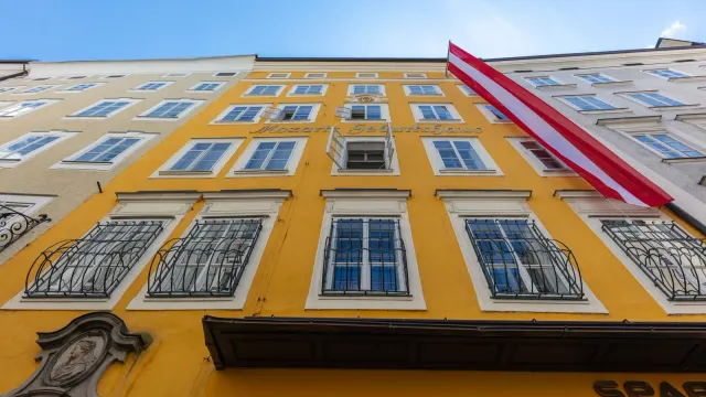 ด้านหน้าสีเหลืองของบ้านโมสาร์ทหลังแรก บ้านเกิด Mozarts Geburtshaus เลขที่ 9 ถนน Getreidegasse เมืองซาลซ์บูร์ก ภาพถ่ายเมื่อ 19 พฤษภาคม 2019