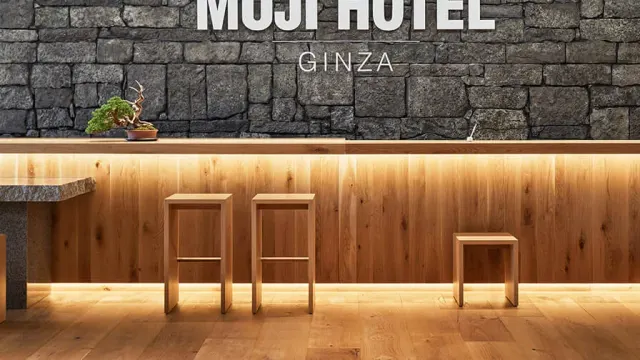 ผนังหินและเคาน์เตอร์ไม้ มีตัวอักษร MUJI HOTEL GINZA ภายในโรงแรมของแบรนด์ MUJI ในโตเกียว