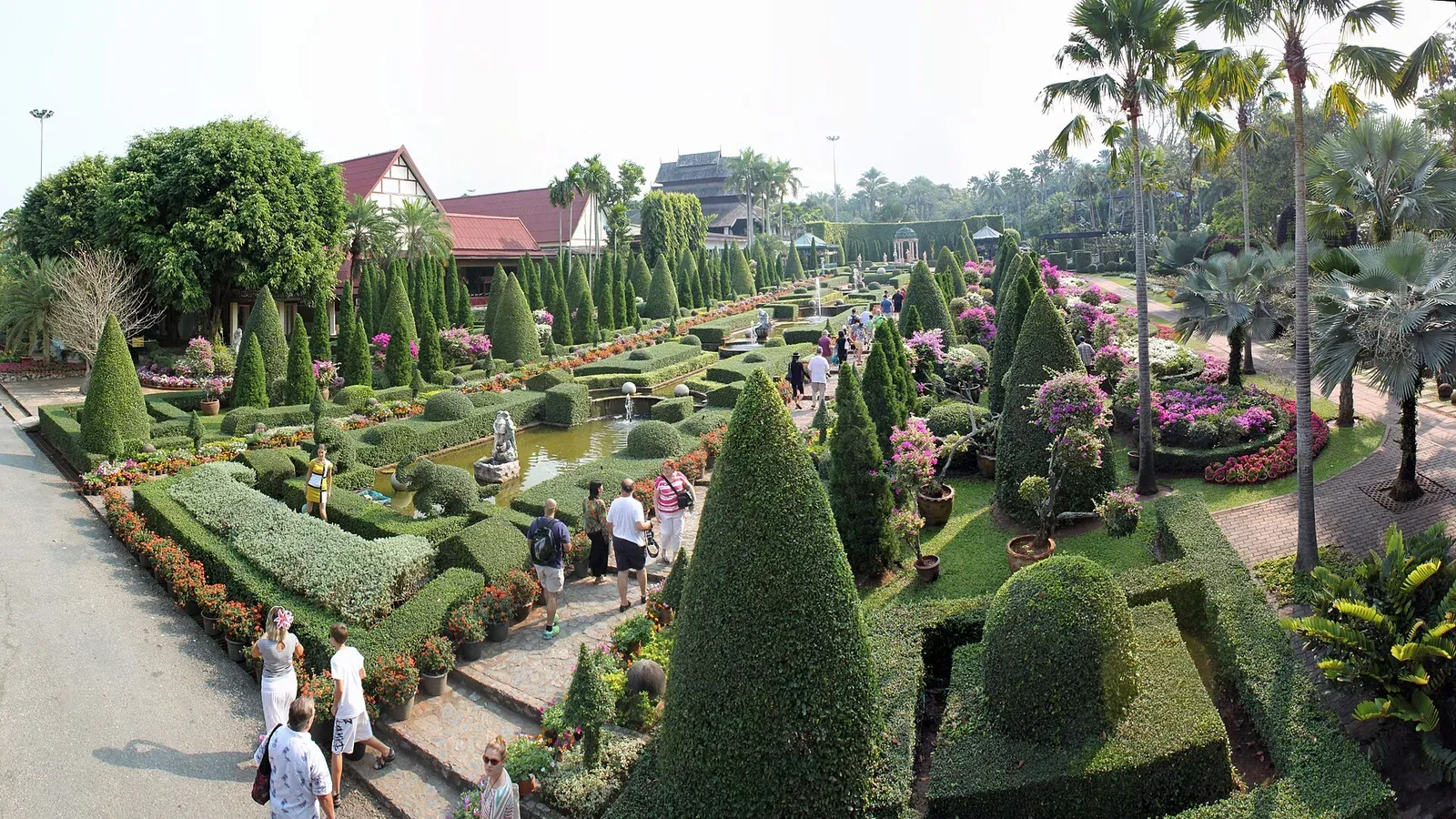 สวนตัดแต่งรูปทรงเรขาคณิตในสวนนงนุช มีผู้มาเยือนเดินชมตามทางเดิน