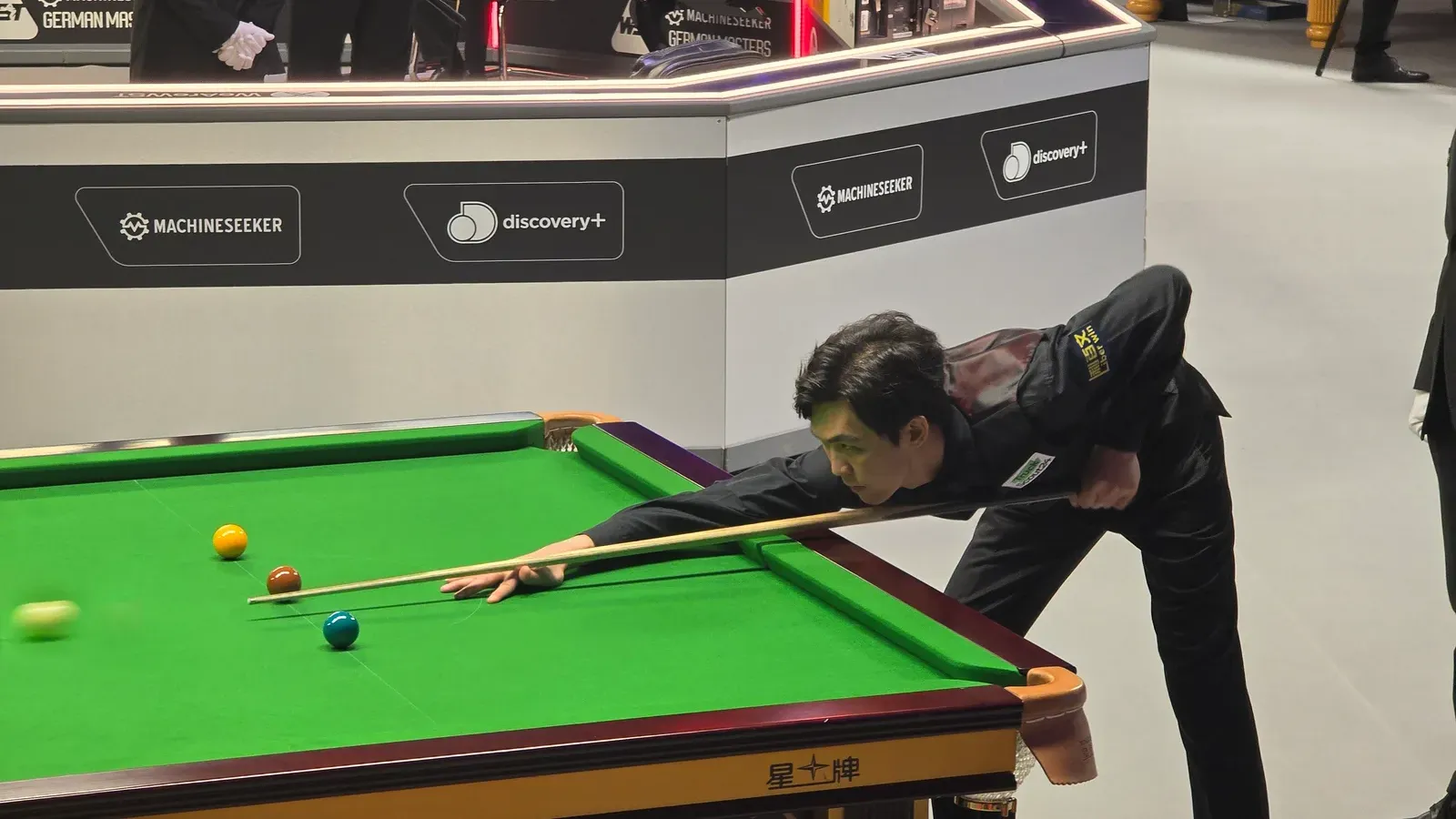 เทพไชยา อุ่นหนู นักคิวไทยในสนุกเกอร์ Northern Ireland Open 2026 ในภาพขณะสวมชุดแข่งสีเข้ม โน้มตัวเล็งไม้คิวบนโต๊ะสนุกเกอร์สีเขียว ที่รายการ German Masters 2025