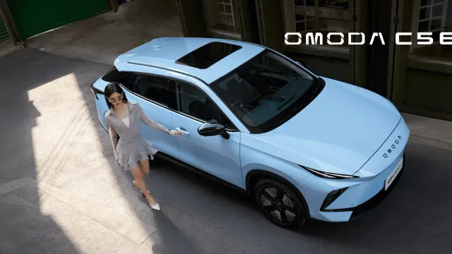 OMODA C5 EV สีฟ้าอ่อน มุมมองจากด้านบน มีผู้หญิงยืนข้างรถ
