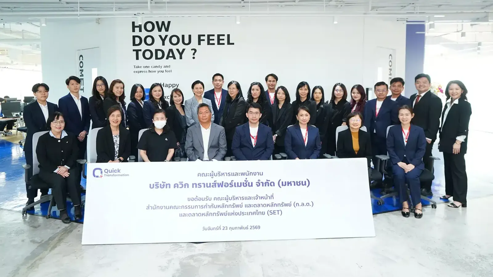 ผู้บริหารและพนักงานบริษัท ควิก ทรานส์ฟอร์เมชั่น ถ่ายภาพหมู่หน้าป้ายต้อนรับคณะผู้บริหารและเจ้าหน้าที่ ก.ล.ต. และตลาดหลักทรัพย์แห่งประเทศไทย วันที่ 23 กุมภาพันธ์ 2569 ก่อน QUICK IPO mai