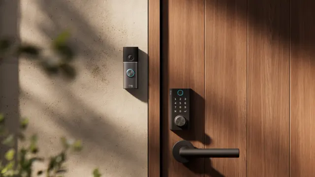 Ring Smart Lock สีดำติดบนประตูไม้ ข้างผนังมีกริ่งประตูวิดีโอ Ring