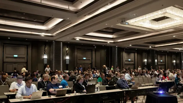 ผู้เข้าร่วมนั่งในห้องประชุม ภาพจากเว็บไซต์ IETF องค์กรที่พิจารณาสัญญาณ robots.txt ห้ามเทรน AI