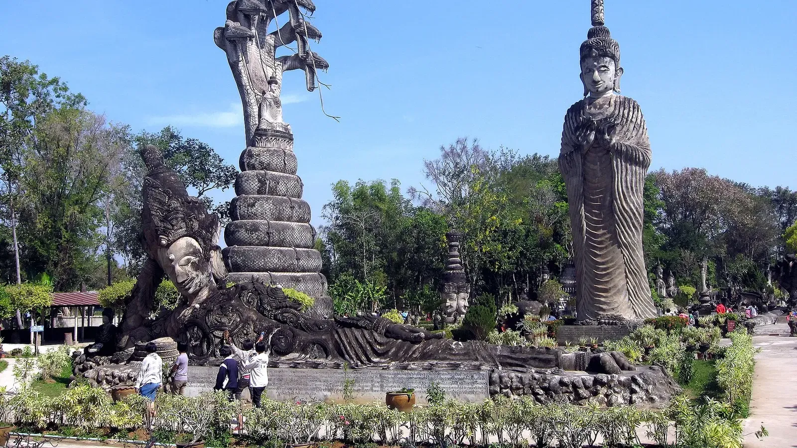 ศาลาแก้วกู่ หนองคาย: รูปปั้นพญานาคหลายเศียรกับรูปปั้นยืนสูงในสวนใต้ท้องฟ้าสีคราม ภาพถ่ายเดือนมกราคม 2010