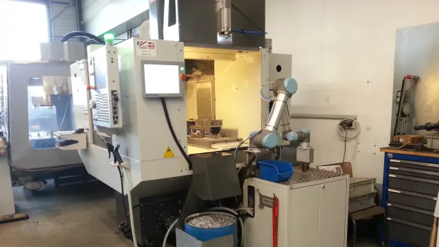 เครื่อง CNC machining center ที่มีแขนหุ่นยนต์ป้อนและนำชิ้นงานออก ภาพปี 2013 จาก EGU-Metall