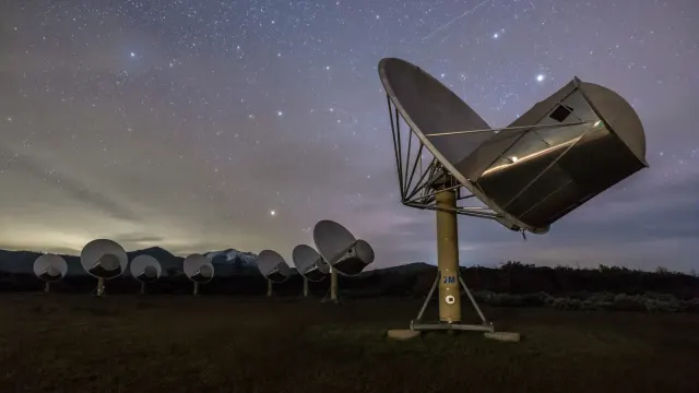 จานรับสัญญาณของ Allen Telescope Array ใต้ท้องฟ้ายามค่ำคืน ภาพประกอบข่าว SETI agentic AI