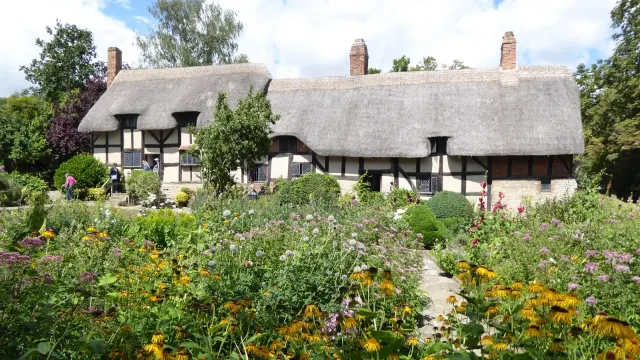 บ้านเชกสเปียร์ หลังที่สอง Anne Hathaway's Cottage บ้านโครงไม้หลังคามุงจากกับสวนคอทเทจด้านหน้า ภาพถ่ายเมื่อ 17 กรกฎาคม 2023