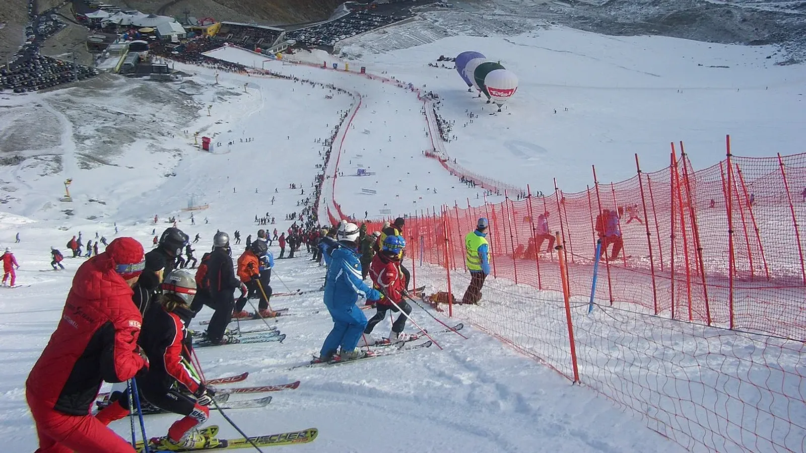 สนามยักษ์สลาลอมบนธารน้ำแข็ง Rettenbach ที่ Sölden ในเวิลด์คัพรายการแรกของฤดูกาล 2008/09 ตาข่ายสีแดงตลอดเส้นทาง เส้นชัย อัฒจันทร์ และบอลลูนลมร้อนด้านล่าง ภาพจากปี 2008