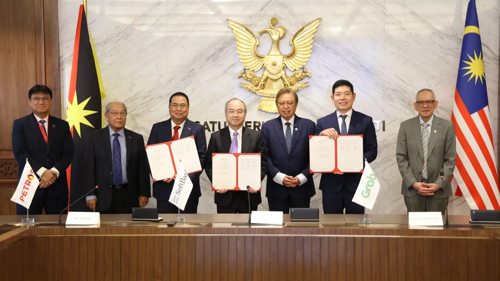 ผู้แทน SoftBank Group, Grab และ PETROS ถือเอกสารข้อตกลงกรอบความร่วมมือเรื่องโครงสร้างพื้นฐาน AI ที่กูชิง ซาราวัก ก่อนข่าว SoftBank ลงทุนมาเลเซีย