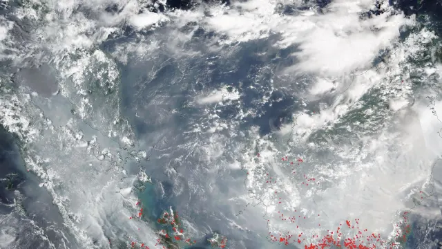 ภาพดาวเทียมสีจริงจากเครื่องมือ VIIRS บนดาวเทียม NOAA-20 วันที่ 8 ตุลาคม 2026 ในวันที่ ASMC รายงานหมอกควันข้ามแดนคลุมพื้นที่นี้ เห็นชั้นสีเทาเหนือสุมาตรา ช่องแคบมะละกา และเกาะบอร์เนียว จุดสีแดงคือจุดความร้อน (thermal anomalies) ที่ VIIRS ตรวจพบในสุมาตราตอนใต้และกาลิมันตันตอนใต้