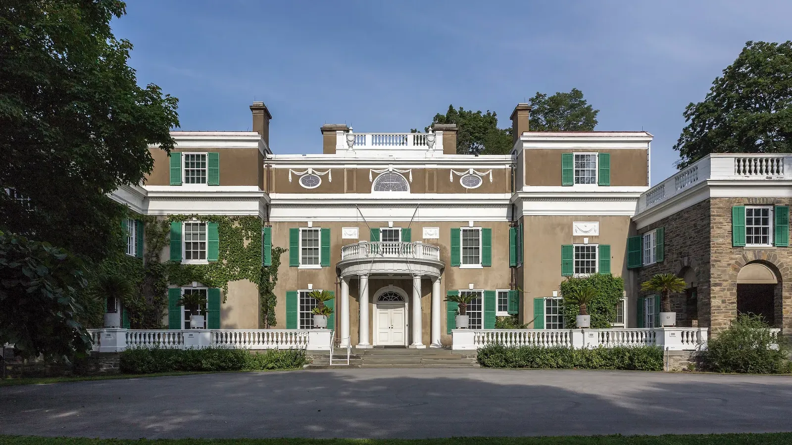 บ้าน Springwood ของ Franklin D. Roosevelt ที่ Hyde Park ด้านตะวันออก คฤหาสน์ผนังสีน้ำตาลอ่อนบานเกล็ดสีเขียว มุขทางเข้าครึ่งวงกลม และลานหน้าบ้าน ภาพถ่ายเมื่อ 28 กรกฎาคม 2016