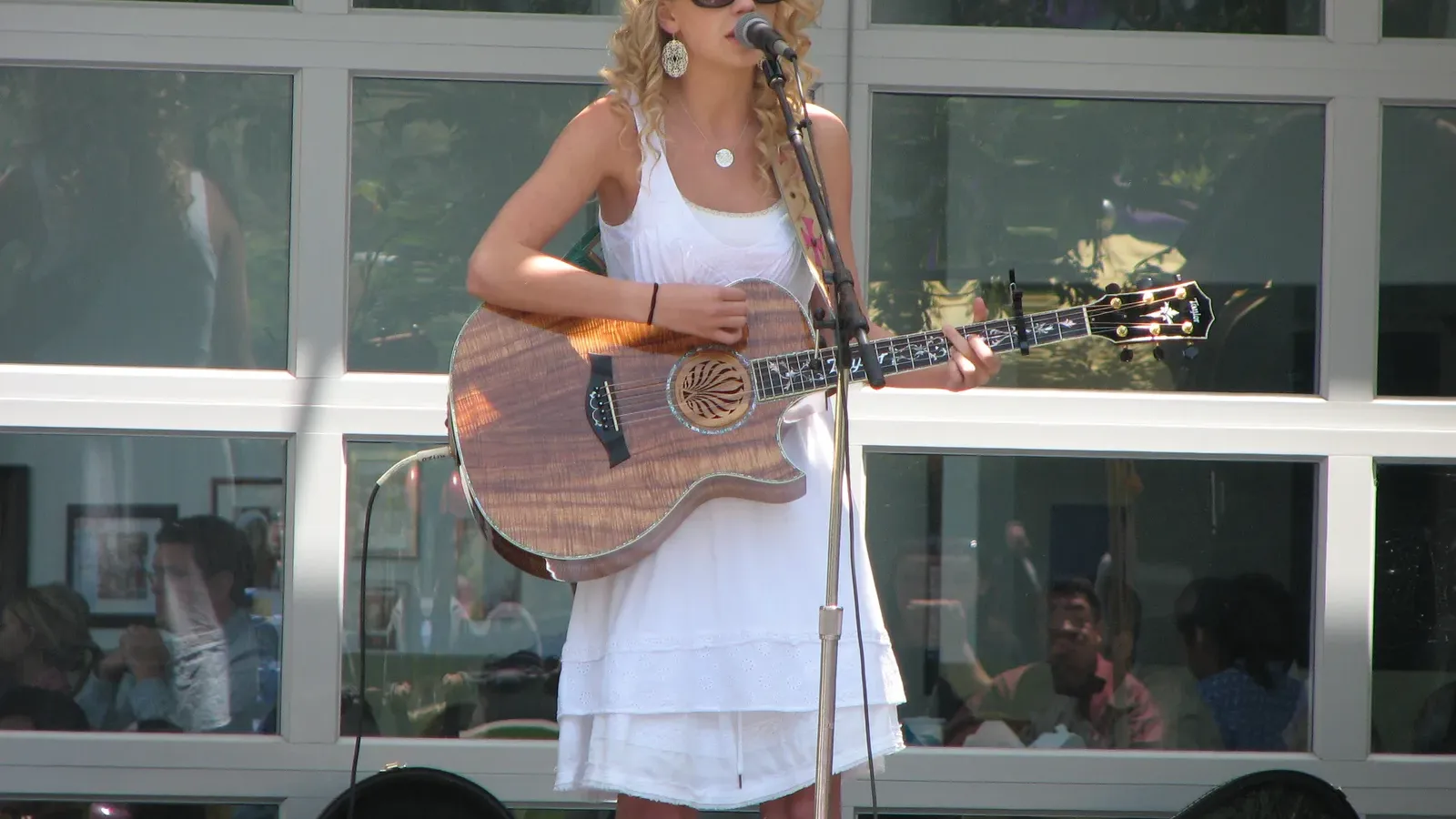 Taylor Swift อัลบั้มแรก 20 ปี: ภาพ Taylor Swift ร้องเพลงพร้อมกีตาร์อะคูสติกที่สำนักงานใหญ่ Yahoo เมื่อ 16 พฤษภาคม 2007 ช่วงโปรโมตอัลบั้มแรก