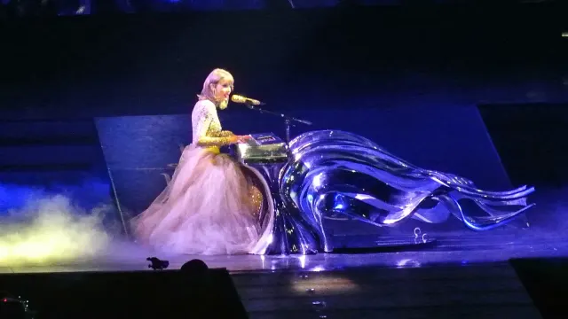 Taylor Swift ในชุดกระโปรงยาวสีชมพูอ่อนเล่นเปียโนบนเวทีช่วงเพลง Wildest Dreams และ Enchanted ในคอนเสิร์ต The 1989 World Tour ที่ STAPLES Center เมือง Los Angeles วันที่ 22 สิงหาคม 2015