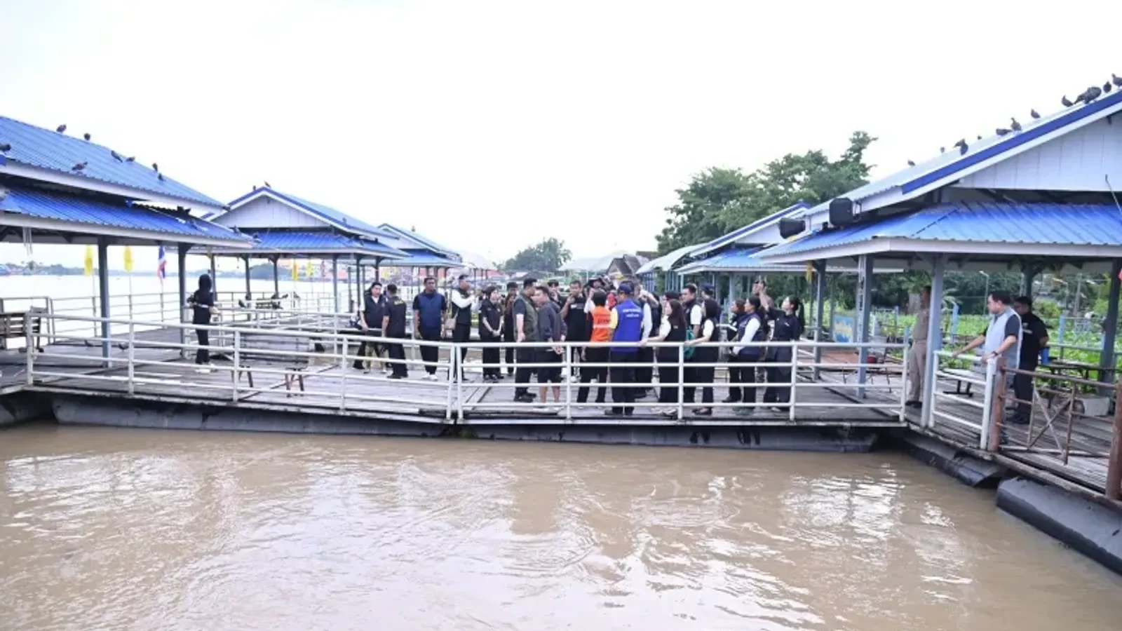 คณะลงพื้นที่ของกระทรวงเกษตรและสหกรณ์บนท่าเรือริมแม่น้ำเจ้าพระยาที่ระดับน้ำสูง ระหว่างติดตามสถานการณ์น้ำท่วมที่อำเภอสามโคก จังหวัดปทุมธานี