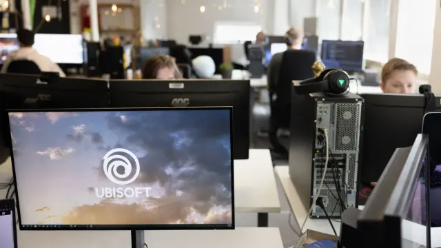 บรรยากาศการทำงานในสตูดิโอ Ubisoft RedLynx ที่ถูกเสนอปิด มีจอคอมพิวเตอร์แสดงโลโก้ Ubisoft บนโต๊ะทำงาน ภาพจากเว็บไซต์ของ RedLynx