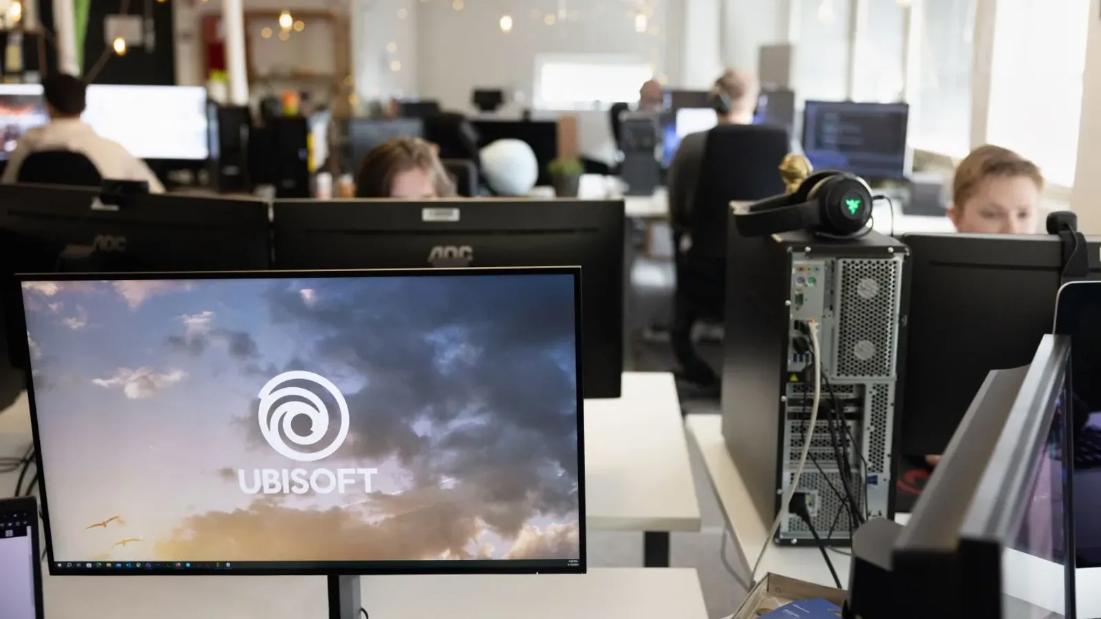 บรรยากาศการทำงานในสตูดิโอ Ubisoft RedLynx ที่ถูกเสนอปิด มีจอคอมพิวเตอร์แสดงโลโก้ Ubisoft บนโต๊ะทำงาน ภาพจากเว็บไซต์ของ RedLynx