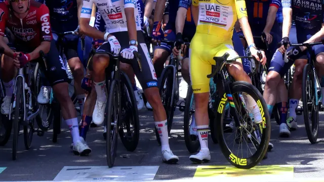Tadej Pogačar ในเสื้อเหลืองและ Isaac del Toro ในเสื้อขาวของ Tour de France 2026 ยืนคร่อมจักรยานเสือหมอบที่เส้นสตาร์ตสเตจ 17 ที่ Chambéry ฝรั่งเศส เมื่อ 22 กรกฎาคม 2026 เห็นชุดแข่ง หมวกกันน็อก แว่น ถุงเท้า รองเท้า และจักรยานของนักปั่นชัดเจน