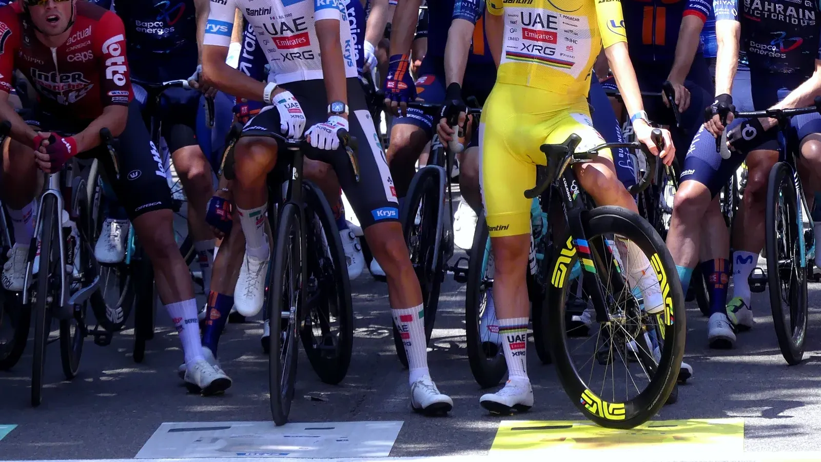 Tadej Pogačar ในเสื้อเหลืองและ Isaac del Toro ในเสื้อขาวของ Tour de France 2026 ยืนคร่อมจักรยานเสือหมอบที่เส้นสตาร์ตสเตจ 17 ที่ Chambéry ฝรั่งเศส เมื่อ 22 กรกฎาคม 2026 เห็นชุดแข่ง หมวกกันน็อก แว่น ถุงเท้า รองเท้า และจักรยานของนักปั่นชัดเจน