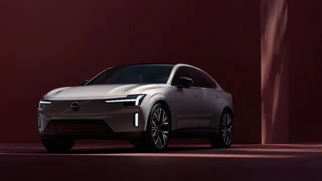 Volvo ES90 สีเทาเงินมุมด้านหน้าเฉียงบนฉากสีแดงเข้ม ภาพจากหน้ารุ่นของ Volvo ประเทศไทย