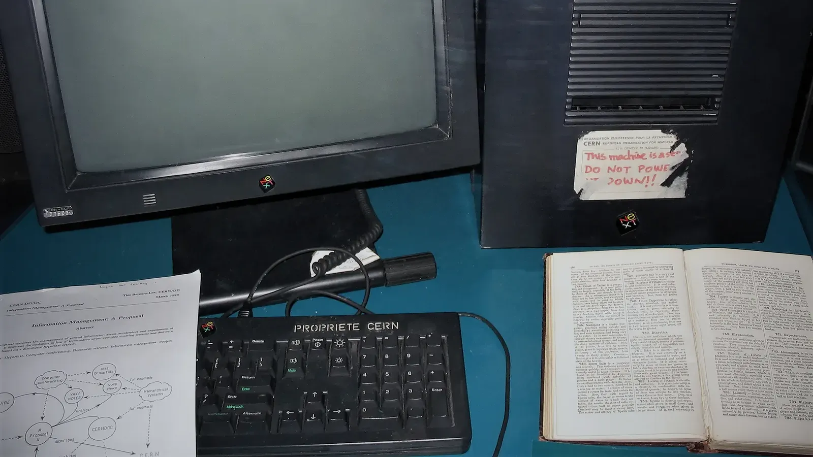 คอมพิวเตอร์ NeXTcube ที่ Tim Berners-Lee ใช้เป็นเว็บเซิร์ฟเวอร์เครื่องแรกของ World Wide Web จัดแสดงใน Microcosm ของ CERN เมื่อปี 2005 ตัวเครื่องมีป้าย PROPRIETE CERN และป้ายลายมือหมึกแดงที่ลอกไปบางส่วนว่า This machine is a server. DO NOT POWER IT DOWN!! บนแป้นพิมพ์มีสำเนาข้อเสนอ Information Management: A Proposal