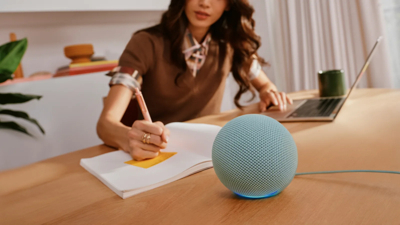 Echo Dot รุ่นใหม่สีเขียวอมฟ้าทรงกลมวางบนโต๊ะทำงาน มีฮับบ้านอัจฉริยะในตัว